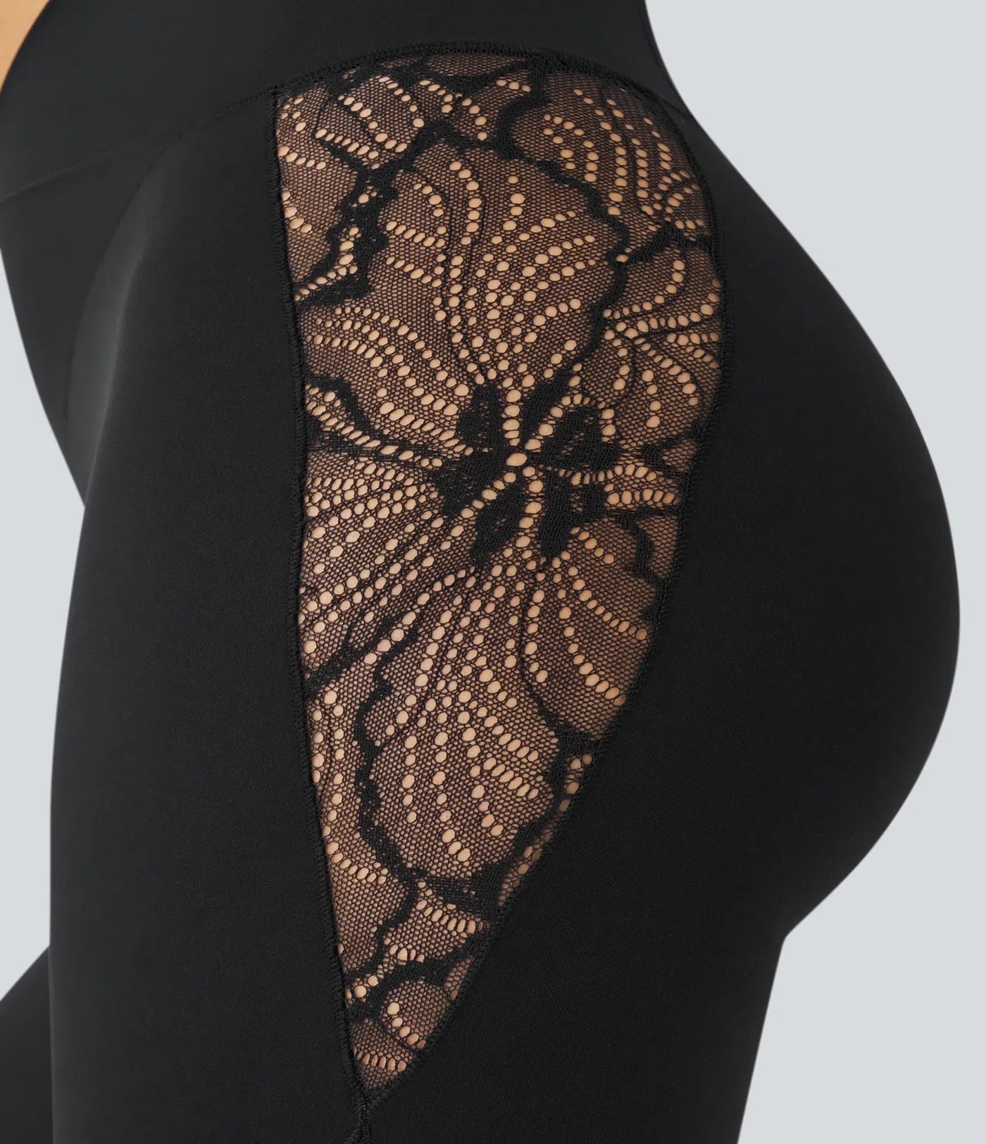 Close-up of FEMORA leggings lace panel and crossover design
